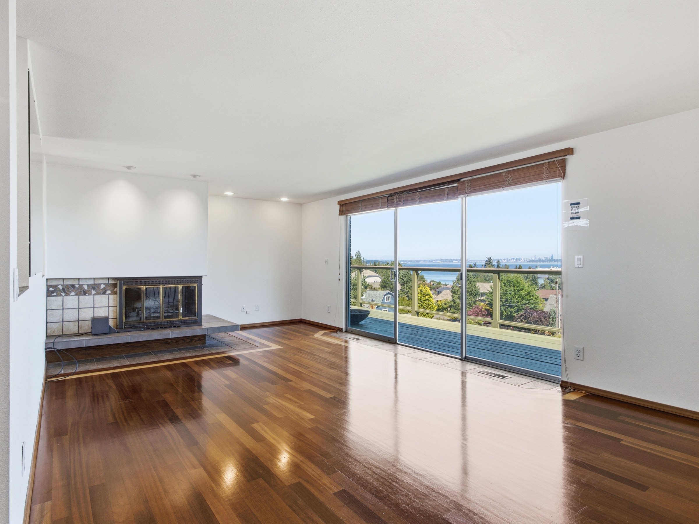 Living room with hardwood floors, fireplace, and exterior water view